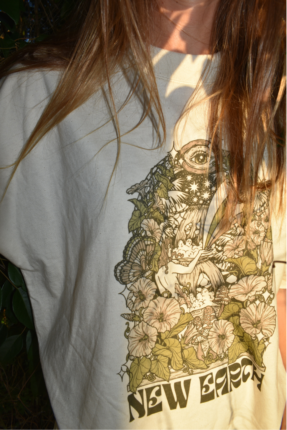 Oversized t-shirt. Beach tee. Unisex. Natural raw colour. New Earth graphic and letters. Coloured flowers. Waterfall. Garden tee