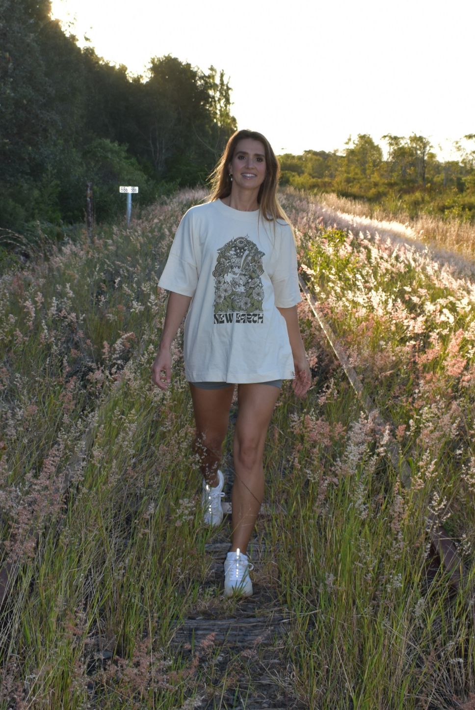 Oversized t-shirt. Beach tee. Unisex. Natural raw colour. New Earth graphic and letters. Coloured flowers. Waterfall. Garden tee